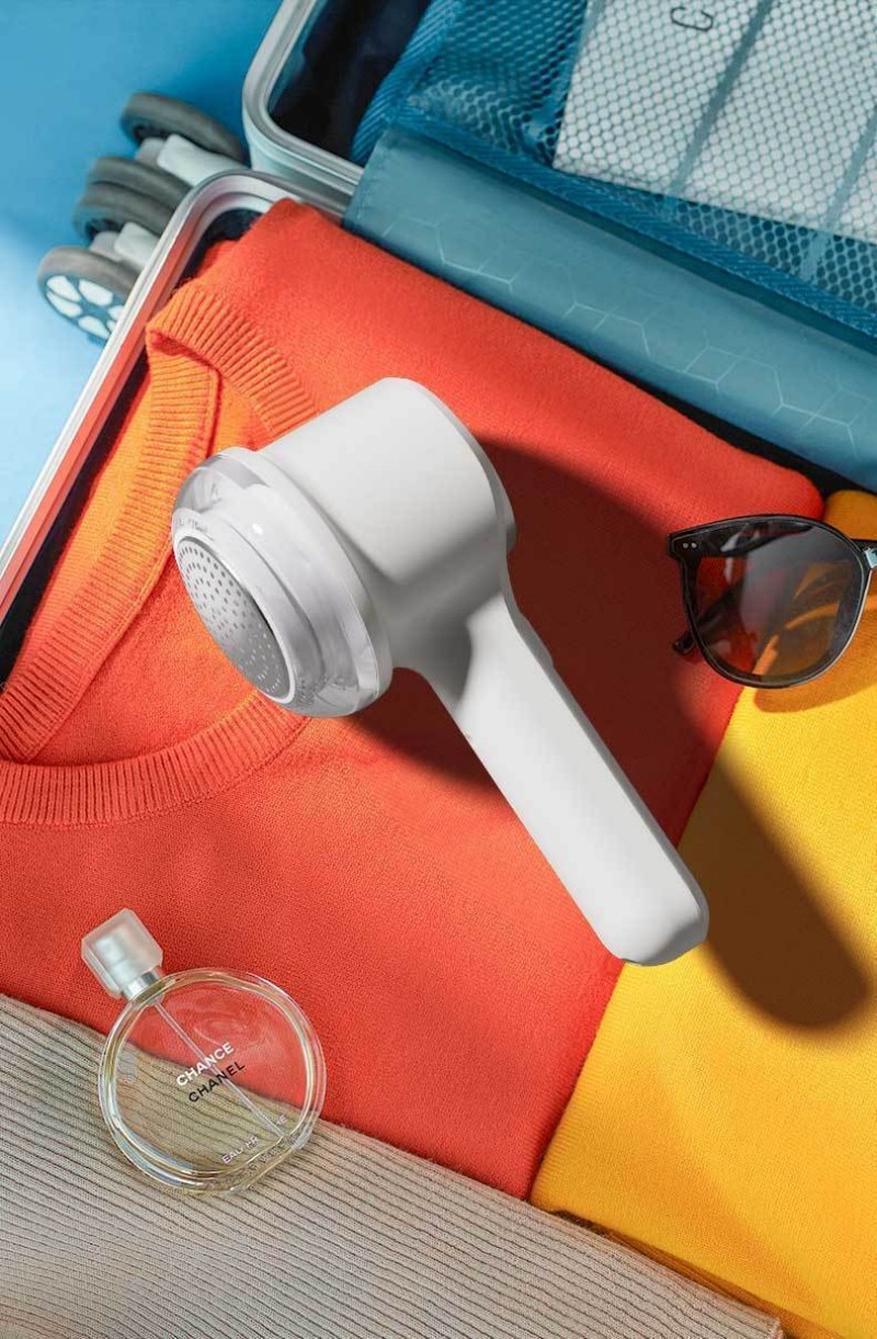 Clothes shaver in use on sofa